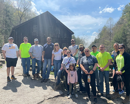 Group of people at a park standing in front of a wooden barn